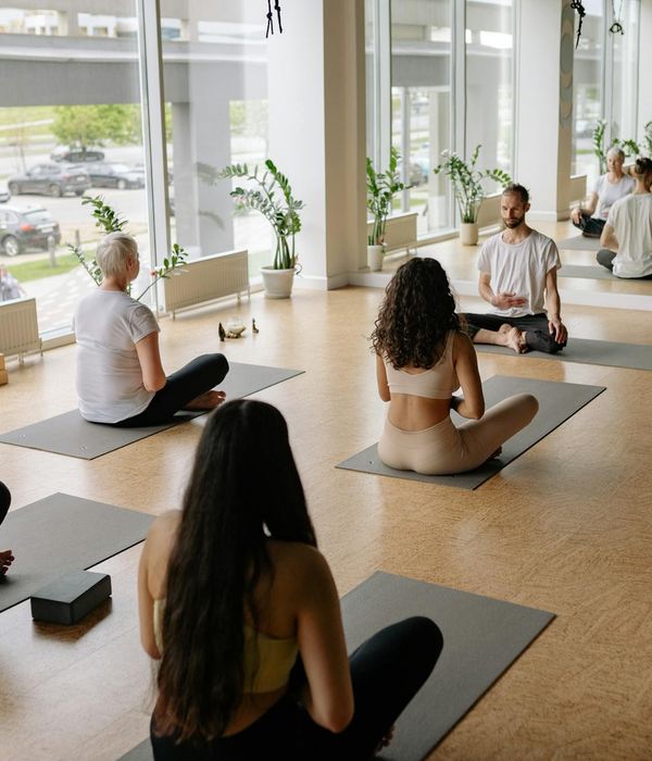 Group of women practicing yoga together in a sunlit studio.
